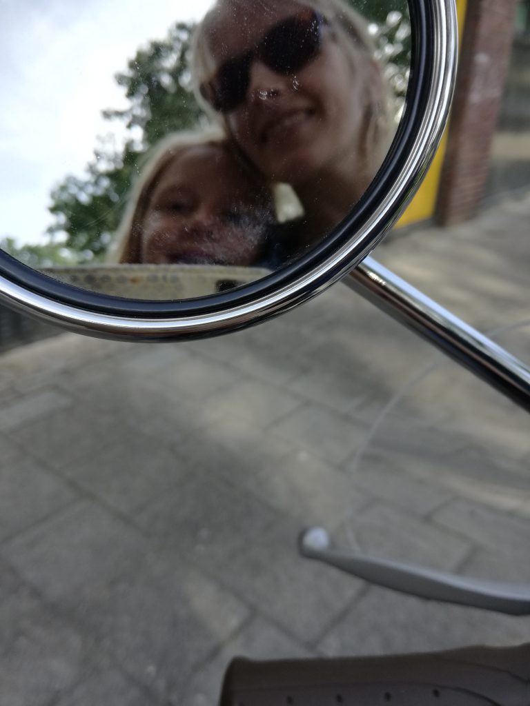 Goede voornemens en mijlpalen
Reflectie van vrouw en meisje in scooterspiegel